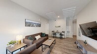 Located at 619 S Kerr Ave in Wilmington, NC, this single-story 2-bedroom, 2-bathroom home offers a clean, modern aesthetic with thoughtful design throughout. The open-concept living and dining area is anchored by wood-look plank flooring, neutral-toned walls, and recessed lighting, creating a bright and welcoming atmosphere. French doors allow natural light to pour into the living space and provide a seamless connection to the outdoors. The kitchen features granite countertops, a center island, white shaker cabinetry, and stainless steel appliances, combining style with everyday functionality. Both bedrooms are well-proportioned, with the primary bedroom offering dedicated workspace and direct access to its own bathroom. The second bedroom benefits from a large window that fills the room with natural light. Each bathroom is finished with granite vanity countertops, undermount sinks, and white cabinetry, maintaining the home's consistent, polished look. Throughout the home, the cohesive use of neutral tones, modern fixtures, and durable flooring creates an inviting and practical living environment well-suited to the Wilmington lifestyle.