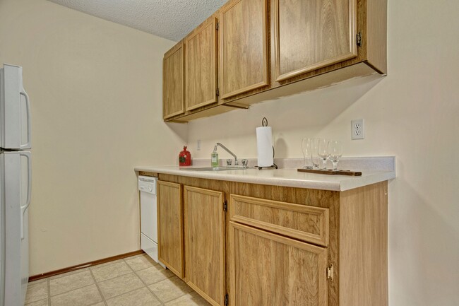 A kitchen with white appliances and light cabinetry - Forest Grove Village