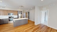 This contemporary apartment in Bloomington, MN offers 1000 square feet of thoughtfully designed living space. The open floor plan seamlessly connects the living area and kitchen, creating an ideal space for entertaining. The gourmet kitchen is a standout feature, boasting sleek two-tone cabinetry, stainless steel appliances, and a stylish subway tile backsplash. A large center island provides additional prep space and casual seating.

The apartment includes two bedrooms, with the primary bedroom spanning a generous 130 square feet. Both bathrooms are modernly appointed, featuring double vanities, ample storage, and refined fixtures. The main living areas showcase beautiful hardwood flooring, while the bedrooms offer plush carpeting for comfort.

Large windows throughout the apartment flood the space with natural light, enhancing the airy feel of the home. Recessed lighting and modern fixtures provide additional illumination. The neutral color palette creates a versatile backdrop for various decor styles.

This single-story residence combines functionality with contemporary design, offering a perfect blend of comfort and style in a prime Bloomington location.