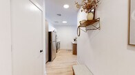 Located at 821 East Main Street in Stamford, CT, this thoughtfully designed one-bedroom, two-bathroom residence offers a well-organized single-floor layout that maximizes every square foot. Light hardwood flooring runs throughout, tying together a clean, contemporary aesthetic accented by crisp white walls and recessed lighting.

The living room is a standout space, lined with large windows on multiple walls that frame sweeping views of the Stamford skyline and surrounding cityscape, filling the room with abundant natural light. The kitchen features stainless steel appliances, two-tone cabinetry with warm wood lower cabinets and white uppers, and a peninsula with a sink — both functional and visually appealing.

The bedroom is a tranquil retreat with a generous footprint, a large window overlooking the city, and warm natural light filtering through sheer curtains. A dedicated office provides a quiet, versatile space with clean lines and open shelving. Both bathrooms are finished with wood-toned vanities, matte black fixtures, white quartz countertops, and tiled flooring — one featuring a tub/shower combination and the other a walk-in shower setup. Throughout, the residence maintains a cohesive modern design with warm, inviting touches.