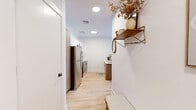 Located at 821 East Main Street in Stamford, CT, this thoughtfully designed one-bedroom, two-bathroom residence offers a well-organized single-floor layout that maximizes every square foot. Light hardwood flooring runs throughout, tying together a clean, contemporary aesthetic accented by crisp white walls and recessed lighting.

The living room is a standout space, lined with large windows on multiple walls that frame sweeping views of the Stamford skyline and surrounding cityscape, filling the room with abundant natural light. The kitchen features stainless steel appliances, two-tone cabinetry with warm wood lower cabinets and white uppers, and a peninsula with a sink — both functional and visually appealing.

The bedroom is a tranquil retreat with a generous footprint, a large window overlooking the city, and warm natural light filtering through sheer curtains. A dedicated office provides a quiet, versatile space with clean lines and open shelving. Both bathrooms are finished with wood-toned vanities, matte black fixtures, white quartz countertops, and tiled flooring — one featuring a tub/shower combination and the other a walk-in shower setup. Throughout, the residence maintains a cohesive modern design with warm, inviting touches.