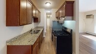 Located at 1425 Colorado Ave S in St. Louis Park, Minnesota, this single-floor residence offers a thoughtfully designed layout with a practical mix of finishes and functional living spaces. The galley-style kitchen is a standout feature, equipped with rich dark wood cabinetry, granite countertops, a double-basin sink, and stainless steel appliances including a gas range and refrigerator. A textured ceiling and flush-mount lighting complete the kitchen's polished look. The living and dining areas are finished with warm hardwood-style flooring and ceiling fans, creating a comfortable and well-lit environment. Large windows with vertical blinds allow generous natural light to fill the main living space. The bedroom features neutral carpet, baseboard heating, and windows that bring in outdoor views, offering a quiet and restful retreat. An additional carpeted room with baseboard heating provides flexible space. The bathroom is clean and functional, featuring a full tub-shower combo with built-in shelving, a granite-topped vanity with dark wood cabinetry, and tile flooring. Throughout the unit, neutral wall tones and consistent trim work create a cohesive and move-in-ready aesthetic suited for comfortable everyday living.