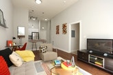 This single-story residence showcases a thoughtfully designed layout with modern finishes and functional living spaces. The living room serves as the heart of the home, featuring warm hardwood flooring, elevated ceilings with a ceiling fan, and a wall-mounted display shelf. A sliding glass door floods the space with natural light and provides direct outdoor access, while a dedicated nook accommodates a workspace.

The kitchen is outfitted with crisp white cabinetry extending to the ceiling, granite-style countertops, and a full suite of stainless steel appliances, including a range, microwave, dishwasher, and refrigerator. Light tile flooring completes the clean, bright aesthetic. An entryway adjoins the kitchen, offering a welcoming transition into the home.

The bedrooms are carpeted for comfort and feature tall ceilings with generous natural light. Each room offers ample wall space suitable for storage and décor. A utility area connects directly to a full bathroom and includes wire shelving for organization alongside a full-size washer and dryer, providing added convenience. The neutral color palette and consistent design language throughout the residence create a cohesive and comfortable living environment.