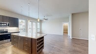 Located in Houston's 77084 zip code, this single-story, 4-bedroom, 5-bathroom home offers a thoughtfully designed open-concept layout with modern finishes throughout. The combined kitchen and living area serves as the heart of the home, featuring warm hardwood-style flooring, recessed lighting, and a ceiling fan that enhances the airy, welcoming atmosphere. The chef's kitchen is outfitted with dark espresso cabinetry, granite countertops, stainless steel appliances, a subway tile backsplash, and a large center island with a built-in wine rack and pendant lighting — ideal for both everyday living and entertaining. Expansive windows and glass doors flood the space with natural light and provide views to the outdoors. The generously sized primary bedroom includes dedicated closet space and an en-suite bathroom featuring elegant floor-to-ceiling tile, a soaking tub, and a separate shower. Three additional well-proportioned bedrooms offer flexibility for guests, offices, or family use, each with hardwood-style floors and access to one of the five bathrooms. A dedicated laundry room is equipped with full-size washer and dryer units, granite countertops, and ample cabinetry for storage, rounding out this well-appointed home.
