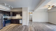Located at 1003 Bluegrass Cir in Cedar Falls, Iowa, this single-floor, 3-bedroom, 2-bathroom unit offers a well-organized and functional layout. The open kitchen and living area form the heart of the home, with the kitchen showcasing rich dark cabinetry, light countertops, and a full suite of stainless steel appliances including a refrigerator, range, microwave, and dishwasher. Hardwood-style flooring runs throughout the main living areas, adding warmth and continuity to the space. The living room is bright and airy, featuring a ceiling fan and sliding glass doors that open to a private balcony with outdoor views — an inviting space for relaxing or entertaining. A dedicated laundry area with washer and dryer hookups adds everyday convenience. The three bedrooms are carpeted for comfort, with the primary bedroom offering a generous footprint and a window with pleasant neighborhood views. The two bathrooms are clean and practical — one features a walk-in shower, while the other includes a full tub-shower combination, both with wood-style flooring and vanity storage. A closet rounds out the layout, providing additional storage. The overall ambiance is neutral, clean, and move-in ready.