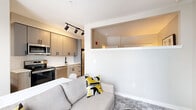 Located at 630 Kenilworth Terrace NE in Washington, DC, this efficiently designed studio presents a thoughtfully organized single-floor layout that maximizes every square foot. A bright, light-toned entry hallway with light hardwood-style flooring and louvered closet doors leads seamlessly into the main living area.

The open-concept kitchen and living room form the heart of the space. The kitchen is outfitted with contemporary gray cabinetry featuring matte black hardware, white subway tile backsplash, white quartz countertops, and a full suite of stainless steel appliances including a range, dishwasher, built-in microwave, and refrigerator. A deep undermount sink with a sleek black faucet completes the well-appointed cooking space. Track lighting overhead adds both function and a modern aesthetic touch.

The living area flows naturally from the kitchen and features plush carpet, neutral walls, and a window offering views of the surrounding Washington, DC streetscape. An architectural half-wall with an open pass-through above creates a subtle visual division while preserving an open, airy feel throughout.

The bathroom is clean and contemporary, showcasing large-format light tile flooring, a full soaking tub with tiled surround, matte black fixtures and hardware, and a wood-toned vanity with a white countertop. The overall design palette throughout is cohesive — neutral, modern, and move-in ready.