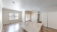 Located in the heart of Austin, Texas, this single-story, three-bedroom, two-bathroom residence offers a well-designed layout with modern finishes throughout. Wood-style plank flooring runs continuously across the home, lending warmth and visual cohesion to every room.

The open-concept kitchen and living area serves as the centerpiece of the home. The kitchen features a large island with a striking marble-style countertop and an integrated sink, complemented by gray cabinetry, subway tile backsplash, stainless steel appliances, and track lighting overhead. The adjacent living area is bright and airy, with large windows and French doors that invite natural light and provide outdoor access.

The spacious primary bedroom includes a ceiling fan, a window with exterior views, and direct access to its own closet. The two additional bedrooms also feature wood-style flooring and ceiling fans. Two full bathrooms mirror each other in design, each offering marble-style vanity countertops, wood cabinetry, and a tiled tub-shower combination. Two generously sized closets with wire shelving systems provide ample storage. Crown molding and neutral gray tones throughout complete the clean, contemporary aesthetic of this well-appointed Austin residence.