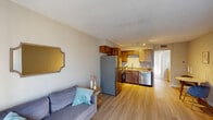 Located in Lake Charles, Louisiana, this single-floor, one-bedroom, one-bathroom residence offers a practical and comfortable layout ideal for individuals or couples. The open-concept living area features light wood-look flooring, neutral warm-toned walls, and a textured ceiling, creating a bright and welcoming atmosphere. Sheer curtains along the living room window allow natural light to filter softly through the space.

The kitchen flows directly from the living area and is equipped with stainless steel appliances, including a refrigerator, electric range, and dishwasher. Rich wood cabinetry provides ample storage, while granite-style countertops add a functional and attractive workspace. A stainless steel sink anchors the counter area, and track lighting overhead ensures the kitchen is well-lit.

The bedroom is a calm and restful retreat, finished with plush carpeting and neutral walls. A large window dressed with sheer curtains invites natural light and connects the room to the outdoors. The bathroom features a granite-top vanity with wood cabinetry, a large mirror, and light flooring, with direct access to the bedroom for added convenience. Overall, this unit presents a clean, cohesive aesthetic with practical finishes throughout.