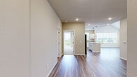 Located at 706 S Main St in Oshkosh, Wisconsin, this well-designed 2-bedroom, 3-bathroom residence offers a thoughtfully laid-out single-floor plan with modern finishes throughout. The kitchen serves as a central highlight, featuring crisp white shaker cabinetry with matte black hardware, granite countertops, a center island with pendant lighting, and a full suite of stainless steel appliances including a refrigerator, range, microwave, and dishwasher. Wood-look luxury vinyl plank flooring runs through the kitchen and main living areas, adding warmth and durability. The living room benefits from vaulted ceilings and large windows that invite abundant natural light and offer views of the surrounding Oshkosh neighborhood. Both bedrooms are carpeted and generously sized, with the primary bedroom featuring vaulted ceilings and direct access to a private balcony with outdoor views. The three bathrooms are finished with granite-top white vanities and wood-look flooring; one includes a walk-in shower, while another offers a full tub-shower combination. Two dedicated closets provide practical storage throughout. The overall aesthetic is clean and contemporary, with neutral warm-beige tones creating a bright, cohesive atmosphere across the entire residence.