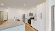 Located on White Oak St SW in Wyoming, Michigan, this single-floor, two-bedroom, two-bathroom residence offers a well-designed layout with consistent modern finishes throughout. Light-toned luxury vinyl plank flooring flows seamlessly across every room, complementing the clean, neutral color palette that defines the interior aesthetic.

The kitchen serves as a functional centerpiece, featuring white shaker-style cabinetry with black hardware, a subway tile backsplash, quartz countertops, stainless steel appliances including a side-by-side refrigerator, electric range, and over-the-range microwave, as well as a peninsula with an undermount sink—ideal for both meal preparation and casual dining.

The open living area benefits from a ceiling fan, recessed lighting, and windows that allow natural light to fill the space. The bedrooms are comfortably sized, with the primary bedroom offering multiple windows, a ceiling fan, and access to a spacious walk-in closet with wrap-around shelving and hanging rods. The primary bathroom includes a dual-sink vanity with quartz countertops, white cabinetry, framed mirrors, and a glass-enclosed walk-in shower. Two closets provide practical storage across the unit.