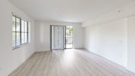 This contemporary 1240 square foot condominium in Boca Ratón offers a harmonious blend of comfort and style. The single-story layout comprises three bedrooms, including a 140 square foot primary suite, and three full bathrooms. The heart of the home is an open-concept kitchen and living area, designed for seamless flow and entertainment. The kitchen boasts sleek white cabinetry, stainless steel appliances, and a spacious island, perfect for casual dining or food preparation.

Large windows throughout flood the space with natural light, while light wood-tone flooring adds warmth and continuity. The bedrooms feature ample closet space with wire shelving systems for optimal organization. Bathrooms are appointed with modern fixtures, including a combination tub-shower with elegant tile work.

A standout feature is the private balcony, offering lush views of palm trees and greenery, creating a tropical oasis. The unit includes an in-unit laundry room with full-sized washer and dryer, adding convenience to daily living. The overall design aesthetic is clean and minimalist, with a neutral color palette that allows for personal touches. This turnkey property at 101 W Camino Real provides a perfect blend of Florida living and modern amenities.