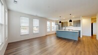 Located at 2223 Lee Rd in Cleveland Heights, Ohio, this well-appointed 2-bedroom, 2-bathroom residence offers a thoughtfully designed single-floor layout. The open-concept living and kitchen area serves as the heart of the home, bathed in natural light from a bank of large windows and a glass door that opens to an outdoor balcony. Warm hardwood-style flooring extends throughout the main living areas, complementing the clean white walls and modern finishes.

The kitchen is a standout feature, showcasing gray shaker-style cabinetry, a stainless steel appliance suite including a refrigerator and range, a wall-mounted range hood, and a striking blue-accented island with a white quartz countertop and matte black pendant lighting overhead. A matte black faucet at the island sink adds a cohesive design touch.

A well-lit hallway with recessed lighting and bold dark-paneled doors leads to the private quarters. The bedrooms are carpeted for comfort — the primary bedroom includes a ceiling fan, while the secondary bedroom features a double-door closet and bright windows with outdoor views. The bathrooms are finished with white subway tile surrounding a soaking tub and shower combination. A dedicated closet provides additional storage, rounding out this modern and functional Cleveland Heights residence.