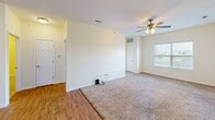 Located at 985 22nd Ave in Silvis, Illinois, this single-floor home offers a well-organized layout with one bedroom and two full bathrooms. The interior features a combination of warm hardwood-style flooring in the kitchen and entryway areas, and plush carpeting throughout the living room and bedroom, creating a comfortable, cohesive feel.

The kitchen is equipped with rich warm-toned wooden cabinetry offering generous storage, complemented by white appliances including a refrigerator, electric range, microwave, and dishwasher. A large skylight-style overhead fixture brightens the space, and the layout flows naturally into the main living area.

The open living area is illuminated by natural light from a window and features a ceiling fan with light kit. The transition between the kitchen's hardwood-style flooring and the carpeted living space adds visual distinction between zones.

The bedroom is a comfortable size, carpeted, and includes a sliding-door closet, a ceiling fan, and a window with blinds for natural light and privacy.

Both bathrooms are finished with neutral tile flooring. The full bath includes a tub/shower combination and a toilet, while a connecting hallway with additional storage access and a vanity provides practical utility. The overall palette of soft cream walls and warm finishes creates a clean, welcoming ambiance throughout.