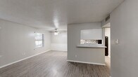 Located at 942 Simpson Terr in Bedford, TX, this single-floor, 2-bedroom, 2-bathroom home offers a well-organized layout designed for comfortable everyday living. The open-concept living and dining area is finished with wood-look plank flooring and features a textured ceiling with a ceiling fan, natural light from a window, and clean neutral walls. A half-wall pass-through with a stone tile accent and granite-style countertop connects the living and dining space to the kitchen, which is equipped with white cabinetry and black appliances. The dining area is accented with classic beadboard wainscoting, adding a touch of character. The spacious primary bedroom features plush carpeting, a ceiling fan, and a sliding glass door that opens to an outdoor area. The second bedroom also includes wood-look flooring, a ceiling fan, and a window for natural light. Both bathrooms are well-appointed; one features large-format subway tile in the tub surround with matching wood-look flooring. A dedicated laundry area adds functional convenience. The consistent use of neutral tones, wood-look flooring, and clean finishes throughout creates a cohesive and move-in ready atmosphere.