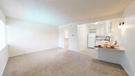 Located at 7923 Reseda Blvd in Reseda, California, this single-floor unit offers a practical and efficient layout comprising a living room, kitchen, closet, and bathroom. The living room serves as the central space of the unit, featuring neutral-toned carpet flooring, white walls, and a textured ceiling. A large window fitted with vertical blinds allows natural light to fill the room, creating a bright and airy atmosphere. A wall-mounted air conditioning unit near the entry door ensures climate comfort, while a small built-in shelf adds a functional touch.

The kitchen is positioned adjacent to the living area and is outfitted with white cabinetry, light countertops, and light wood-style vinyl flooring. It includes essential appliances such as a full-size refrigerator and an electric range with a ventilation hood, along with a sink with a modern matte black faucet — making it a functional space for everyday meal preparation.

The bathroom features a clean, white aesthetic with a single-sink vanity topped by a round mirror, overhead storage cabinetry, and a shower-tub combination. The closet provides dedicated storage space. Throughout the unit, the consistent white color palette and well-maintained finishes contribute to a clean, move-in-ready feel.
