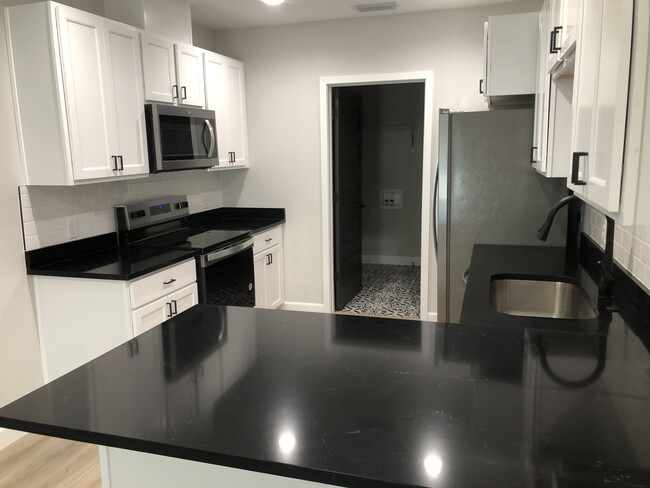 kitchen will new stainless steel appliances and black quartz. White subway tile for backsplash - 410 N West St