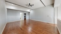 Located at 310 E 1st St in Tulsa, OK, this two-story urban loft blends industrial character with modern finishes across a well-proportioned layout spanning two floors. The lower level showcases polished concrete floors, soaring ceilings with exposed ductwork, and a sleek kitchen featuring dark countertops, stainless steel fixtures, and white cabinetry. A dramatic steel-and-wood staircase with mesh railings anchors the main living area, while a striking exposed brick wall adds raw, historic texture and natural light filters in through tall windows. The lower level also includes a full bathroom with a glass-enclosed shower and polished concrete flooring. Ascending to the upper floor, rich hardwood flooring extends throughout the spacious living room, which is illuminated by track lighting and a ceiling fan. The generously sized bedroom features hardwood floors and track lighting, accompanied by a walk-in closet with built-in shelving and hanging rods. A second full bathroom on this level offers a glass-door shower, floating vanity with ample storage, a large mirror, and tile flooring. A dedicated laundry room with full-size washer and dryer completes the upper level. This loft offers a compelling mix of urban industrial aesthetics and practical, comfortable living.