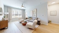 Located at 10633 Newtown Woods Trail in Louisville, KY, this well-appointed one-bedroom, two-bathroom residence offers a thoughtfully designed single-floor layout with generous living space. Light hardwood flooring flows throughout, complementing the neutral, soft-toned walls that create a bright and cohesive aesthetic.

The open-concept kitchen and living area serves as the heart of the home. The kitchen is outfitted with dark espresso cabinetry, granite countertops, a white subway tile backsplash, and a full suite of stainless steel appliances. A kitchen island with bar seating provides additional prep and dining space. The adjoining living room receives abundant natural light through large windows, features a ceiling fan, and opens directly to a private outdoor area via a glass-paneled door.

The spacious primary bedroom is a calm retreat with soft natural light, neutral tones, and access to two closets — including a walk-in closet equipped with wire shelving systems for efficient organization. Both bathrooms are finished with granite-topped dark vanities and tile flooring. The primary bath includes a glass-enclosed walk-in shower with white subway tile, while the second bath offers a full soaking tub and shower combination. A hallway connects the living areas to the private spaces, completing this clean and functional floor plan.
