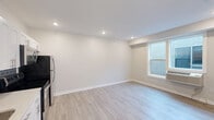 Located at 1528 W Girard Ave in Philadelphia's vibrant Francisville neighborhood, this one-bedroom, one-bathroom unit offers a clean, modern aesthetic with quality finishes throughout. The open living and kitchen area is anchored by light-toned luxury vinyl plank flooring and recessed lighting, creating a bright and welcoming atmosphere. The kitchen is a standout feature, boasting crisp white shaker cabinets, a grey subway tile backsplash, light quartz countertops, and a full suite of stainless steel appliances including a refrigerator, electric range, microwave, and dishwasher. A double closet near the entry provides convenient storage. The spacious bedroom features plush wall-to-wall carpeting, a ceiling fan, a bright window with exterior views, and a wall-mounted HVAC unit for personalized climate control. The bathroom is finished with neutral tile flooring, a rich dark wood vanity with undermount sink, a frameless wall mirror, and a tiled shower-tub combination. Throughout the unit, clean white walls, bright recessed lighting, and consistent trim work contribute to a cohesive, contemporary feel that is both functional and inviting.