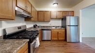 Located at 7755 S Scepter Dr in Franklin, Wisconsin, this single-floor residence offers three bedrooms and two bathrooms within a practical and efficiently arranged floor plan. The living area features neutral-toned carpet and a ceiling fan, with a baseboard heating system running along the exterior wall. An open passage connects the living space to the kitchen, which is well-equipped with warm wood cabinetry, granite-style countertops, and a full suite of stainless steel appliances including a gas range, dishwasher, and refrigerator. The kitchen also features durable hardwood-style flooring, adding a warm contrast to the lighter tones throughout the rest of the home. The generously sized primary bedroom provides ample living space, while the two additional bedrooms are bright and clean with plush carpeting and built-in closets featuring bi-fold doors. Both bathrooms are thoughtfully designed — one includes a full tub/shower combo with a white surround and hardwood-style flooring, while the second features a wide vanity with a white countertop, wood cabinetry, and a mirrored medicine cabinet. A hallway and dedicated closet space add to the home's overall storage and functionality.