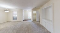 This 2-bedroom, 3-bathroom single-story home in Columbus, GA offers a well-organized layout designed for comfortable everyday living. The space features two living areas, providing flexible options for lounging, dining, or a dedicated workspace. The main living room is generously sized, featuring soft carpeting and a built-in shelving and cabinet unit that adds both storage and character to the room.

The kitchen is outfitted with warm wood-toned cabinetry, granite-style countertops, hardwood-style flooring, and black appliances including a refrigerator and dishwasher. It connects seamlessly to a secondary living or dining area illuminated by a pendant light and a window.

A standout secondary room features floor-to-ceiling built-in bookshelves lining both walls, hardwood-style flooring, a ceiling fan, and multiple windows that invite natural light — ideal as a home office or library.

The spacious primary bedroom spans a generous footprint with plush carpeting and connects to a walk-in closet equipped with dual hanging rods and shelving. Additional closets throughout the home provide ample storage. The three bathrooms feature hardwood-style flooring and include tub/shower combinations. The neutral, light-toned palette throughout creates a clean and cohesive ambiance.