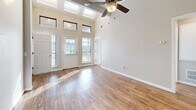 Located at 2001 S Country Club Rd in El Reno, Oklahoma, this one-bedroom, two-bathroom unit is designed to maximize both comfort and functionality within a smartly efficient footprint. The living area makes an immediate impression with soaring vaulted ceilings, skylights, and transom windows flanking the front entry door, flooding the space with abundant natural light. Warm wood-look laminate flooring runs throughout the main living areas, complementing the bright, neutral color palette. The open-concept layout seamlessly connects the living room, dining area, and kitchen, creating an airy and cohesive entertaining space. The kitchen is well-appointed with white shaker-style cabinetry, sparkling quartz countertops, a peninsula breakfast bar, stainless steel appliances including a refrigerator and gas range, and a built-in sink. A ceiling fan adds comfort overhead. The generously sized primary bedroom features plush carpeting, multiple windows with outdoor views, a ceiling fan, and ample closet storage. Both bathrooms offer clean white vanities and wood-look flooring. A dedicated laundry room and a hallway with additional closet space round out the practical layout of this well-appointed home.