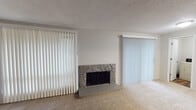 This single-floor unit at 147 S 340th St in Federal Way, Washington offers a practical and comfortable layout designed for everyday living. The living room serves as a welcoming focal point, anchored by a stone-surround wood-burning fireplace and flanked by sliding glass doors dressed with vertical blinds, allowing natural light to filter through. The space features wall-to-wall carpet throughout the main living areas and bedrooms, contributing to a warm and quiet atmosphere.

The kitchen is efficiently designed with white cabinetry, ample counter space, a built-in dishwasher, and wood-look flooring that extends into the adjacent laundry area. A dedicated laundry room houses a full-size washer and dryer, providing in-unit convenience. A central hallway connects the private areas of the home, leading to multiple carpeted bedrooms. Each bedroom offers a neutral palette and adequate closet space, with select rooms featuring windows that bring in natural light.

The bathroom includes a full-size tub and shower combination, a single vanity with a large mirror, and wood-look flooring that ties into the rest of the unit's design. Textured ceilings are consistent throughout. The overall layout is functional and straightforward, making this a well-organized single-level living space in a residential Federal Way community.