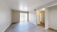 This 2-bedroom, 1-bathroom unit offers a thoughtfully designed single-floor layout that maximizes functionality and comfort. The open living area features wood-look flooring in a light gray tone, neutral-painted walls, and a sliding glass door that fills the space with natural light while providing access to an outdoor area. The kitchen is well-equipped with white cabinetry, granite countertops, a stainless steel sink, and a full suite of stainless steel appliances including a refrigerator, range, and microwave. A tray ceiling detail adds architectural interest to the kitchen area. Both bedrooms are comfortably sized, each featuring wood-look flooring, neutral walls, and window blinds that allow for natural light control. The primary bedroom includes a sliding door leading to a walk-in closet with built-in shelving, offering generous storage. A dedicated walk-in pantry with floor-to-ceiling shelving is an additional storage highlight. The bathroom features a granite-topped vanity, a full tub-shower combination, and a large mirror. A connecting hallway ties all rooms together efficiently, completing this clean and modern living space.