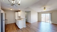 Located at 1434 W Lark St in Springfield, Missouri, this single-floor, three-bedroom, two-bathroom home offers a practical and comfortable layout. The open-concept living and kitchen area serves as the heart of the home, where rich hardwood-style flooring flows throughout. The kitchen is well-appointed with white cabinetry, marble-look countertops, stainless steel appliances including a refrigerator, range, and microwave, and a peninsula that provides additional counter space and casual dining potential. A ceiling fan in the living area and sliding glass doors leading to the outdoors bring in natural light and ventilation. Each of the three bedrooms features plush carpeting and a ceiling fan, with the secondary bedrooms offering windows that invite natural light. The primary bedroom includes closet access, providing functional storage. Three total closets are distributed throughout the home. The bathrooms are clean and functional, with one featuring a full tub-shower combination. A hallway connects the bedrooms and bathrooms, providing a clear and efficient floor plan. The neutral color palette and consistent finishes throughout create a cohesive, move-in-ready atmosphere suitable for a variety of lifestyles.