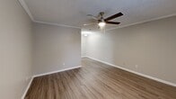 Located at 11300 Mesa Dr in Little Rock, AR, this single-floor, one-bedroom, one-bathroom unit offers a practical and well-appointed layout. The living area greets you with warm hardwood-style flooring, neutral gray walls, and crown molding that adds a classic touch. A ceiling fan with a built-in light fixture provides both comfort and illumination, while a window fitted with horizontal blinds allows natural light to filter in. The layout flows into a compact kitchen equipped with white cabinetry, a refrigerator, and a range, keeping essentials within easy reach. The bedroom features plush wall-to-wall carpeting, a ceiling fan, and a window overlooking the outdoors. A built-in closet provides convenient storage space. Textured ceilings are consistent throughout the unit, contributing to its traditional character. The bathroom is highlighted by a full tub and shower combo enclosed by large-format, stone-look ceramic tile in warm beige tones, lending a clean and polished finish. Chrome fixtures complete the look. Throughout the unit, consistent neutral tones, ceiling fans in each main room, and a straightforward single-level floor plan make this a functional and comfortable space in the heart of Little Rock.
