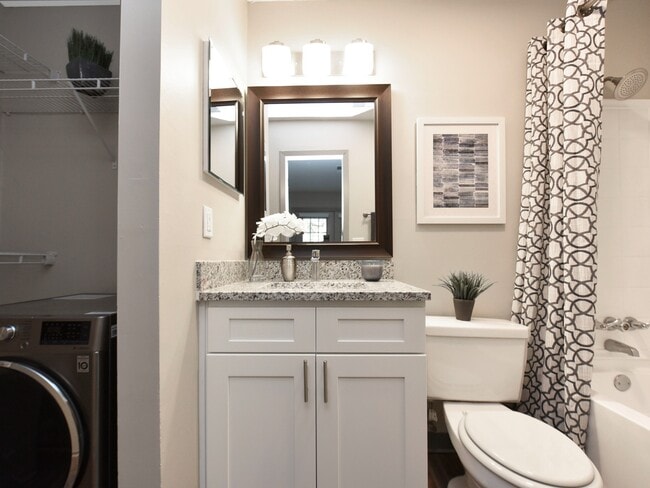 Baño luminoso con encimeras y bañera de granito. - Copper Pointe