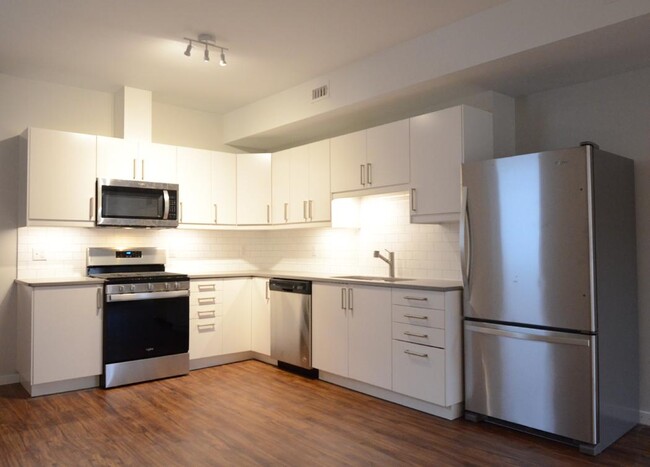 Well-appointed open kitchen. (quartz counters, subway tile back splash, stainless steel appliances) - 904 Main St