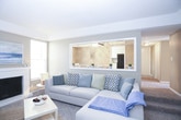 This single-floor residence offers a thoughtfully designed layout with a variety of functional and comfortable spaces. The kitchen is outfitted with white cabinetry, ample counter space, and a full suite of black appliances, including a gas range, built-in microwave, dishwasher, and refrigerator. Light-toned tile flooring and a window above the sink keep the space bright and practical.

The dining area is a standout feature, showcasing a tray ceiling accented by a ceiling fan with lighting, warm neutral walls with chair rail molding, and a window that fills the room with natural light — ideal for everyday meals or entertaining.

The living area is carpeted and generously sized, with large windows that invite natural light. A secondary sitting area provides additional flexible space for relaxation or recreation.

Multiple bedrooms are present throughout the home. The primary bedroom features plush carpeting, a window, and a walk-in closet. Additional bedrooms are also carpeted and well-lit by natural light, with window sills that offer convenient built-in ledge space.

The bathroom includes a wide vanity with a stone-finish countertop, an undermount sink, white cabinetry, and a large mirror, conveying a clean and functional aesthetic. Warm neutral tones are carried consistently throughout the home, creating a cohesive and inviting atmosphere.