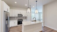 Located at 2648 Sandy Plains Rd in Marietta, GA, this thoughtfully designed 2-bedroom, 2-bathroom residence offers a clean, modern aesthetic across a single floor. The open-concept kitchen and living area serves as the heart of the home, anchored by a large center island with granite countertops, an undermount sink with a matte black faucet, and stylish pendant lighting. White shaker cabinetry, a subway tile backsplash, and stainless steel appliances complete the kitchen. Rich hardwood-style flooring extends throughout the main living areas, adding warmth and continuity. A versatile den, accessed via a striking sliding barn door, provides abundant natural light through oversized windows with outdoor views. The primary bedroom is generously sized with plush carpet flooring and direct access to an en-suite bathroom featuring granite countertops, white cabinetry, a backlit vanity mirror, matte black hardware, and a glass-enclosed walk-in shower with large-format tile. The second bedroom is well-proportioned with carpet flooring, a ceiling fan, and a bright window. Four closets offer ample storage throughout. A dedicated laundry room, utility room, and a private balcony round out this well-appointed residence.
