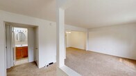 Located at 606 Sturwood Way in Lawrence Township, NJ, this single-floor, 2-bedroom, 1-bathroom home offers a functional and straightforward layout. The living room is bright and welcoming, featuring large windows that invite abundant natural light and offer views of the surrounding greenery. Soft neutral carpet runs throughout the living and bedroom areas, creating a warm, cohesive feel. The front entry, visible through a half-wall pass-through, features a classic paneled door with transom windows above. The kitchen is efficiently arranged in a U-shape, showcasing warm honey-toned wood cabinetry, white appliances including a range, dishwasher, and refrigerator, and light ceramic tile flooring. A window above the sink brings in natural light. The spacious primary bedroom offers generous proportions, with a large closet providing ample storage. The second bedroom is well-sized with its own window framing outdoor views. The full bathroom is finished with neutral beige tile surrounding a tub-shower combination, lending a clean and timeless aesthetic. A hallway connects all areas of the home, ensuring a practical and easy-to-navigate floor plan throughout.