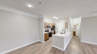 This 750 square foot, single-story apartment in Burford, GA offers a blend of comfort and contemporary design. The space features an open-concept layout that maximizes the living area. Upon entry, you're greeted by a spacious living room with large windows that flood the area with natural light. The room is adorned with a modern ceiling fan and elegant crown molding.

The kitchen is a highlight, boasting wood-tone cabinetry, stainless steel appliances, and a sleek white countertop with a breakfast bar. A herringbone tile backsplash adds a touch of sophistication. The living and kitchen areas are unified by light-toned wood-look flooring, creating a seamless flow.

The bedroom, measuring 160 square feet, features plush carpeting and a ceiling fan for comfort. It includes a window for natural light and is painted in neutral tones. The bathroom is modern and functional, with a single vanity, large mirror, and contemporary lighting fixtures.

Throughout the apartment, you'll find neutral wall colors, white trim, and ample electrical outlets. The property includes two closets for storage. Crown molding throughout adds an elegant touch to this compact yet well-designed living space.