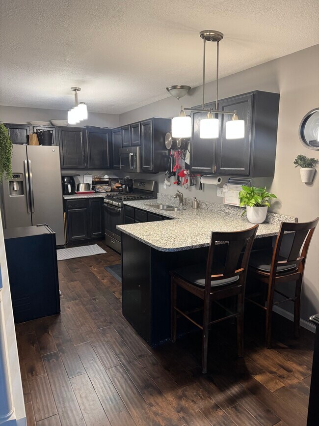 Cocina con barra para sentarse - 4430 104th St