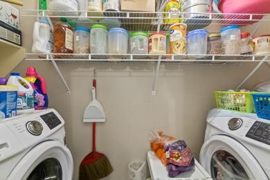 Food pentry and laundry room with Samsung front load washer and dryer - 7721 Misty Ridge Dr N