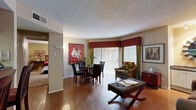 This well-appointed 2-bedroom, 1-bathroom residence is thoughtfully laid out across a single floor, offering a functional and comfortable living environment. The combined living and dining area serves as the heart of the home, featuring warm hardwood-style flooring, a textured ceiling, and a sliding glass door that floods the space with natural light and provides direct access to a private balcony. A built-in shelving unit adds both storage and visual interest to the living area.

The galley-style kitchen is efficiently designed with white cabinetry, dark countertops, subway tile backsplash, and black appliances including a range, dishwasher, and full-size refrigerator, all set atop durable wood-look flooring.

The primary bedroom is generously sized, featuring plush carpeting, a ceiling fan with light fixture, and direct access to a walk-in closet with built-in shelving and hanging rods. The full bathroom includes a shower-tub combination. A dedicated laundry area accommodates a full-size side-by-side washer and dryer. Two hallways connect the spaces efficiently, and additional closet storage is available throughout. The layout is practical and well-suited for everyday living.