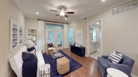 This single-floor residence offers a thoughtfully designed layout with a cohesive neutral color palette, warm hardwood-style flooring, and crown molding that lends a polished character to the main living areas. The living room is a welcoming focal point, featuring a ceiling fan, recessed lighting, and French doors that invite natural light and provide views of the outdoors. Built-in shelving adds functional detail, while open sightlines connect seamlessly to the dining area, which is anchored by an elegant chandelier and decorative columns that define the space without enclosing it.

The kitchen is equipped with white cabinetry, granite countertops, stainless steel appliances, and a classic tile backsplash, offering both style and practicality. The primary bedroom features plush carpeting, a ceiling fan, and a walk-in closet, with a private en-suite bathroom that includes dual sinks, granite countertops, pendant lighting, and a separate shower. A second bedroom is equally comfortable with carpeted floors and ceiling fan, served by a full bathroom featuring a tub-shower combination, granite vanity, and tile flooring. Together, these spaces create a refined and functional living environment.