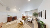 Located in Eagle, Idaho, this well-appointed 2-bedroom, 2-bathroom single-floor home offers a thoughtfully designed layout ideal for comfortable everyday living. The open-concept kitchen and living area serves as the heart of the home, where warm wood-toned cabinetry reaches toward the ceiling, complemented by crisp white quartz countertops, a peninsula with bar seating, and a full suite of stainless steel appliances including a refrigerator, range, and microwave. Light hardwood-style flooring flows throughout the main living areas, anchoring the bright and airy atmosphere. The living room features recessed lighting, wainscoting panel detailing along the lower walls, and windows fitted with horizontal blinds that allow ample natural light to filter in. Both bedrooms are carpeted and generously sized, with the primary bedroom offering access to its own bathroom and natural light from a window. Each bathroom includes a tiled tub-shower combination with a curtain rod finished in brushed metal hardware. A dedicated laundry area with a full-size top-loading washer and dryer adds everyday convenience. The hallway connects all rooms efficiently, completing this cohesive and functional floor plan.