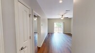 Located at 1115 Ashland Road in Columbia, Missouri, this well-appointed 2-bedroom, 2-bathroom residence offers a comfortable and functional single-floor layout. Rich hardwood-style flooring flows throughout the living areas and bedrooms, complemented by neutral-toned walls and ceiling fans that add both style and practicality to each room. The open living room receives natural light and provides sliding glass door access to a private wooden balcony overlooking a fenced, tree-lined yard — a serene outdoor retreat. The galley-style kitchen is thoughtfully equipped with warm wood cabinetry, dark granite countertops, stainless steel appliances including a refrigerator, electric range, and microwave, as well as a double sink. The spacious primary bedroom offers comfortable proportions, while the second bedroom also features hardwood-style flooring and a window for natural light. Both bathrooms echo the kitchen's design with granite-topped vanities and tile flooring. A dedicated laundry area houses a full-sized washer and dryer. A connecting hallway ties the layout together efficiently, making this residence a practical and inviting home in Columbia, MO.