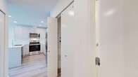 Located at 750 Robinson Street in Coquitlam, BC, this three-bedroom, one-bathroom home offers a thoughtfully designed single-floor layout with a clean, modern aesthetic throughout. Light-toned laminate wood flooring runs consistently across the entire space, creating a cohesive and welcoming atmosphere.

The kitchen is a standout feature, finished with white flat-panel cabinetry, a white subway tile backsplash, light quartz countertops, and stainless steel appliances. A space-saving sliding barn-style door provides access to an in-unit laundry area tucked conveniently nearby.

The three bedrooms are bright and airy, benefiting from generous natural light through large windows. The primary bedroom offers a walk-in closet with built-in shelving. Select bedrooms frame views of the surrounding greenery, while others overlook the Coquitlam city skyline with high-rise towers visible in the distance — a notable feature that adds urban character to the space.

The bathroom is finished in a contemporary style with light wood-toned cabinetry, a wall mirror, a clean white vanity with integrated sink, and a full bathtub with a shower. The overall palette of whites and natural tones gives the home a fresh, move-in-ready feel throughout.