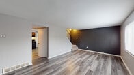 Located at 4312 Westport Rd in Columbus, Ohio, this two-story home offers a practical and modern layout spread across two levels. The main floor welcomes you with durable luxury vinyl plank flooring in a neutral gray-toned wood finish, flowing through the living and dining areas. The living room features a bold dark accent wall and a staircase leading to the upper level, creating a visually distinct focal point. Natural light filters in through a front-facing window, offering views of the surrounding neighborhood. The kitchen is well-appointed with warm wood cabinetry, light granite-style countertops, a double-basin sink, and a black dishwasher. A half bathroom on the main level provides added convenience, featuring a pedestal sink and a clean, minimal design. Upstairs, multiple carpeted bedrooms offer a comfortable retreat, each finished in neutral gray tones with natural light from exterior-facing windows. The bedrooms include closets with built-in rods for storage. A full bathroom on the upper level includes a tub-shower combination with tile flooring. Throughout the home, clean lines, neutral color palettes, and updated finishes contribute to a move-in ready, functional living environment.