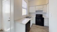 This single-floor unit offers a clean, functional layout with a neutral color palette and a mix of durable wood-style flooring and plush carpet throughout. The open-concept living and dining area flows naturally into the kitchen, which is equipped with white cabinetry, light countertops, a black electric range, dishwasher, and refrigerator. A window above the sink brings in natural light, keeping the space bright and airy.

The hallway connects the main living areas to the bedrooms, each carpeted for comfort and fitted with windows dressed in horizontal blinds. One bedroom features a ceiling fan and a large corner window that allows ample natural light. A sliding glass door in the living area opens to a private patio, offering views of the surrounding exterior.

The unit includes two bathrooms. The primary bathroom features an extended vanity with a wide countertop, dual mirrors, white cabinetry, and an adjoining shower area. The secondary bathroom is compact and efficient, complete with a tub-shower combo, toilet, and vanity with under-sink storage, finished with wood-style flooring.

Overall, the space presents a straightforward, move-in-ready layout with consistent finishes and practical amenities throughout.