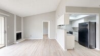 This one-bedroom apartment at Addison Apartments At The Park offers a thoughtfully designed living space of 540 square feet. The unit features a modern, open-concept layout that maximizes functionality and comfort. The living area is spacious and bright, with light-colored walls and durable wood-look flooring that extends throughout the apartment.

The kitchen, though compact, is well-equipped with white cabinetry, a sleek black appliance package including a refrigerator and electric range, and a practical countertop space. Adjacent to the kitchen is a small dining area, perfect for casual meals or as a workspace.

The bedroom, measuring 150 square feet, is generously sized for a one-bedroom unit. It features a large window allowing natural light and a sliding glass door leading to a private balcony, offering an outdoor extension of the living space. The apartment includes a walk-in closet with built-in shelving and hanging rods, providing ample storage solutions.

The bathroom, while not explicitly shown, likely contains standard fixtures and continues the apartment's modern aesthetic. Throughout the unit, recessed lighting and a ceiling fan in the living area contribute to the overall ambiance and comfort.

The neutral color palette and clean lines create a versatile canvas for various decorating styles, making this apartment an ideal choice for those seeking a contemporary, low-maintenance living space in a convenient location.