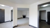 This single-floor residence presents a clean, neutral palette throughout, creating a bright and adaptable living environment. The interior is characterized by crisp white walls, dark contrasting baseboards, and plush wall-to-wall carpeting that lends a sense of warmth and comfort underfoot.

The living area is a standout feature, anchored by a classic fireplace with a sleek surround that serves as a natural focal point for the room. The open archway connecting the entry and living spaces enhances the sense of flow and continuity, making the layout feel spacious and well-connected.

The overall design is understated and timeless, with smooth ceilings and clean wall finishes that provide a versatile backdrop suited to a wide range of interior styles. The interconnected rooms allow for flexible use of the space, whether for entertaining or everyday living.

The absence of clutter and furnishings in the current state highlights the architectural bones of the property — the generous proportions of each room, the thoughtful transitions between spaces, and the consistent finish details throughout. This space offers a strong foundation for personalization, ready to be transformed into a comfortable and stylish home.