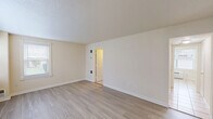 Located at 5255 Hampton Gardens Dr in Northampton, MA, this two-story home offers four bedrooms, two bathrooms, and a practical, well-organized layout spread evenly across two floors. The main level features a bright living room with light wood-style flooring, a large window with blinds that floods the space with natural light, and a textured ceiling. The kitchen is efficiently designed with white cabinetry, stainless steel appliances including a gas range, microwave, refrigerator, and dishwasher, complemented by light tile flooring and a window overlooking the exterior. A second kitchen on this level adds notable versatility. Both bathrooms are clean and functional — one includes a tub and a privacy window with grab bars, while the other features a walk-in shower stall with chrome fixtures and tile flooring. The bedrooms are carpeted with neutral tones, offering a comfortable and quiet atmosphere. The spacious primary bedroom includes its own access point and ample room for furnishings. Six closets distributed throughout the home provide generous storage. A dedicated laundry area and two staircases add to the home's convenience and accessibility. The overall aesthetic is clean, neutral, and move-in ready.