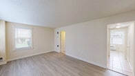 Located at 5255 Hampton Gardens Dr in Northampton, MA, this two-story home offers four bedrooms, two bathrooms, and a practical, well-organized layout spread evenly across two floors. The main level features a bright living room with light wood-style flooring, a large window with blinds that floods the space with natural light, and a textured ceiling. The kitchen is efficiently designed with white cabinetry, stainless steel appliances including a gas range, microwave, refrigerator, and dishwasher, complemented by light tile flooring and a window overlooking the exterior. A second kitchen on this level adds notable versatility. Both bathrooms are clean and functional — one includes a tub and a privacy window with grab bars, while the other features a walk-in shower stall with chrome fixtures and tile flooring. The bedrooms are carpeted with neutral tones, offering a comfortable and quiet atmosphere. The spacious primary bedroom includes its own access point and ample room for furnishings. Six closets distributed throughout the home provide generous storage. A dedicated laundry area and two staircases add to the home's convenience and accessibility. The overall aesthetic is clean, neutral, and move-in ready.