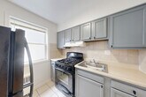 Located at 1934 Naylor Rd SE in Washington, DC, this 2-bedroom, 1-bathroom unit offers a practical and well-maintained single-floor layout. Warm-toned hardwood flooring extends throughout the bedrooms and hallway, lending a consistent and inviting feel to the space. Both bedrooms feature white walls, natural light from windows, and clean, simple layouts — the primary bedroom includes a closet and connects directly to the hallway for easy access. The kitchen is equipped with gray cabinetry, a tile backsplash, a gas range, a stainless steel sink, and tile flooring, offering a functional cooking space. The full bathroom features white square subway-style wall tiles surrounding a full bathtub, complemented by a window that brings in natural light. A hallway connects the rooms efficiently within the compact footprint. The unit's clean, neutral palette throughout — white walls, light-toned floors, and simple fixtures — creates a bright and easy-to-personalize living environment. Overall, the space provides a straightforward and functional layout suitable for everyday residential living in the Southeast DC neighborhood.